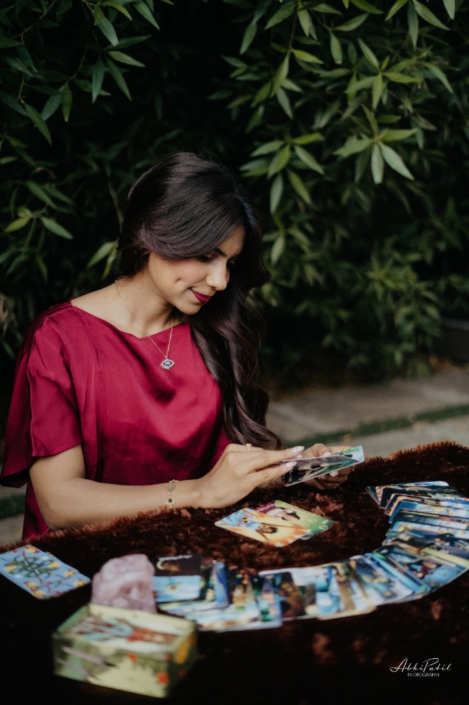 Vedika conducting an outdoor tarot reading among greenery